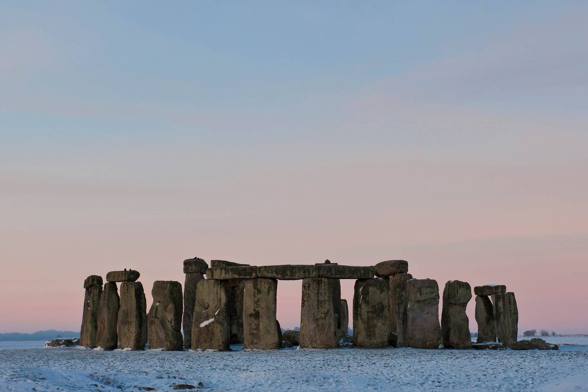 Stonehenge stone monuments silhouetted against a clear dusk sky