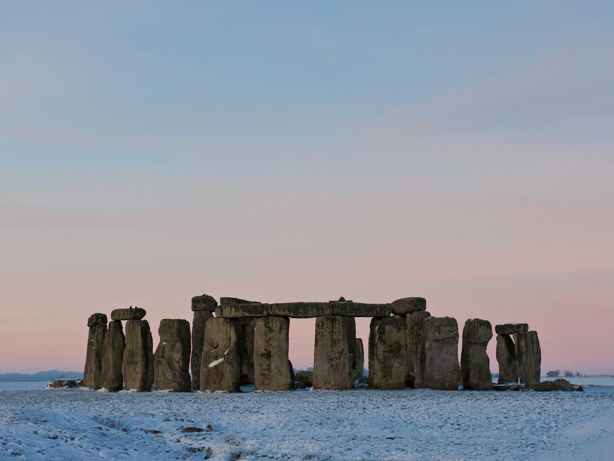 Stonehenge stone monuments silhouetted against a clear dusk sky